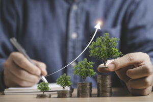 businessman holding trees growing on increasing coins stacking f