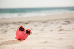 piggy bank with sunglasses kept sand (1)